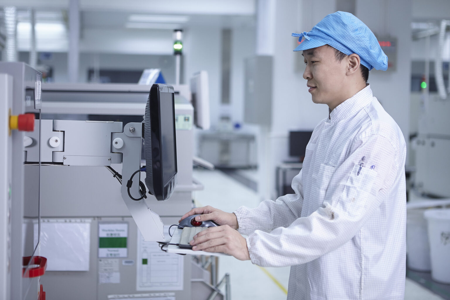 worker using computer in factory that specialises in creating functional circuits on flexible surfaces