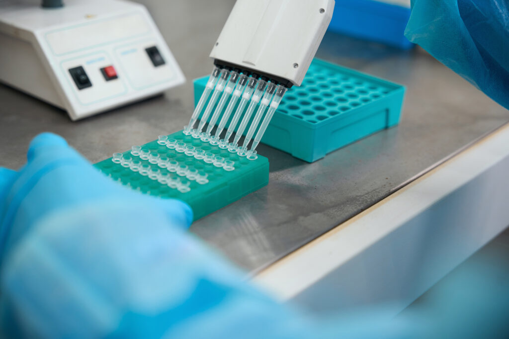 Multichannel pipette filling PCR tube strips placed in a cooling rack during sample setup