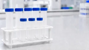 Clear centrifuge tubes with blue screw caps in a lab rack, showing subtle leakage risk around the cap area